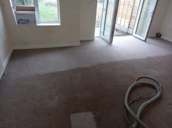 This is a photo of an empty living room with a brown carpet that is in the process of having its carpets steam cleaned works carried out by Tooting Carpet Cleaning